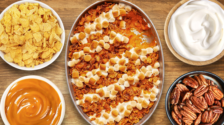 A sweet potato casserole is surrounded by various ingredients.