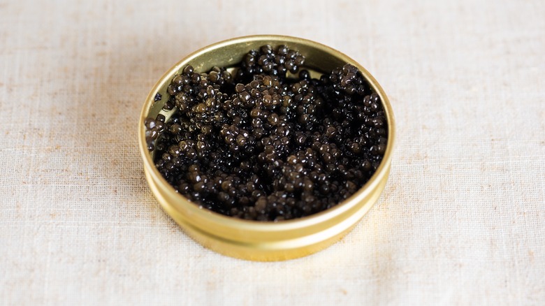 Gold tin of caviar on white countertop