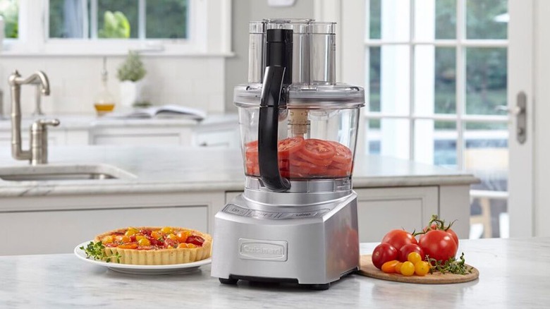 Cuisinart Elite Collection 12 Cup Food Processor on kitchen counter next to fresh tomatoes and a tomato tart