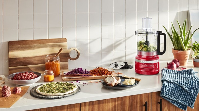 KitchenAid Food Processor on kitchen counter surrounded by various prepared foods