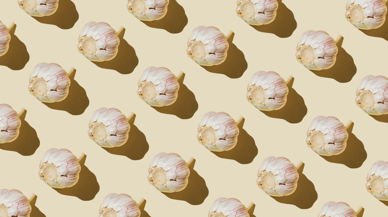 multiple garlic bulbs against tan background