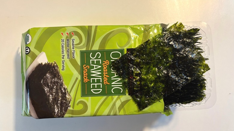 Kirkland Seaweed Snack package with one seaweed snack on top on white table