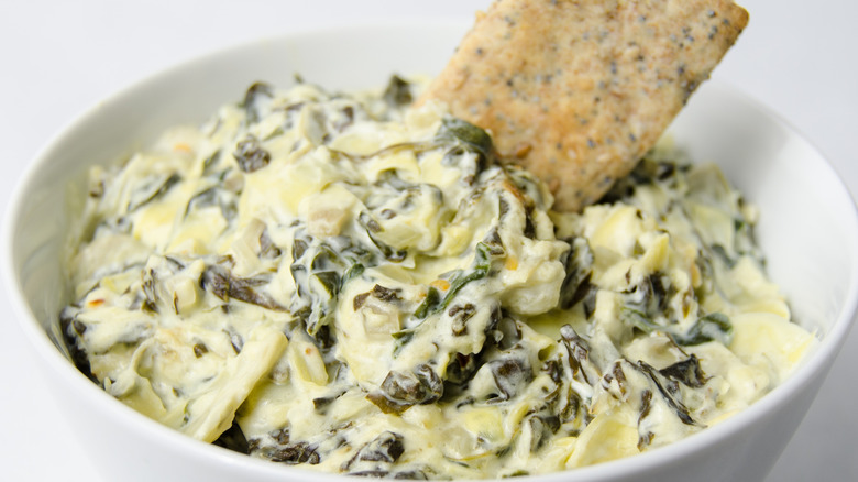 spinach dip in bowl with crackers