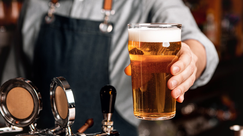 bartender handing clear craft beer