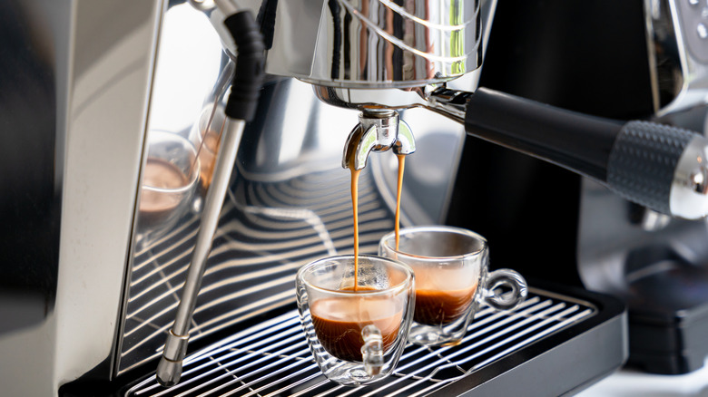 A machine is brewing two cups of espresso.