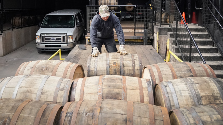 Man loading bourbon barrels on flatbed