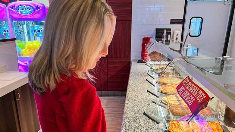 girl at Cici's Pizza buffet with games in background