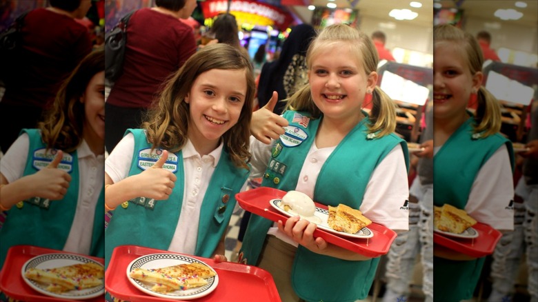 Girl Scouts with food trays at Incredible Pizza in front of game entrance