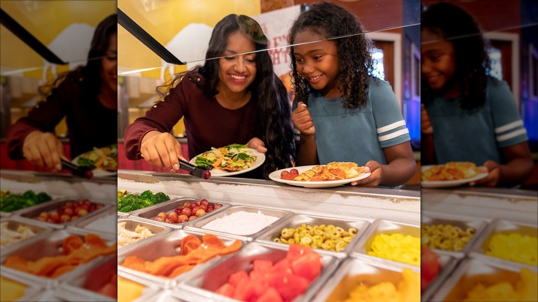 people getting food from Pizza Ranch buffet with game room glow