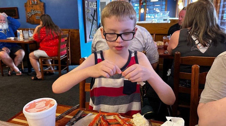 kid eating crab legs at The Original Benjamin's Calabash Seafood