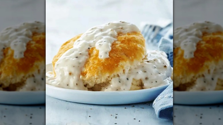 Biscuit and gravy on plate with napkin