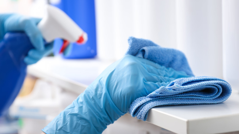 Wiping shelf with rubber gloves and a sponge