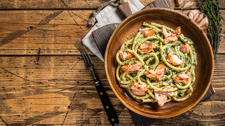 bucatini pasta with smoked salmon on wooden background