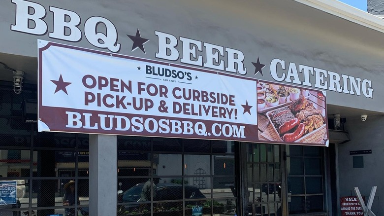 Bludso's BBQ sign hanging outside of entrance