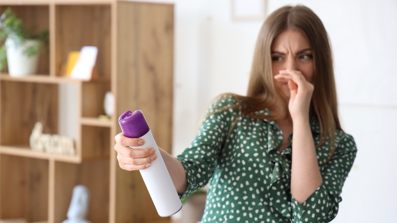 woman spraying air freshener