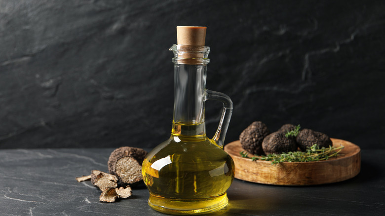 Bottle of oil with fresh truffles in the background