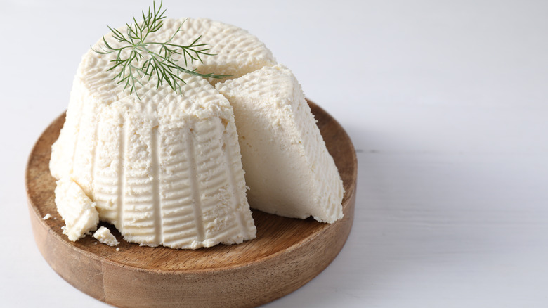 Fresh ricotta cheese on circular cutting board