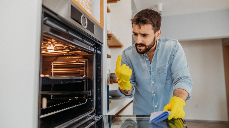 Man checking dirt in oven