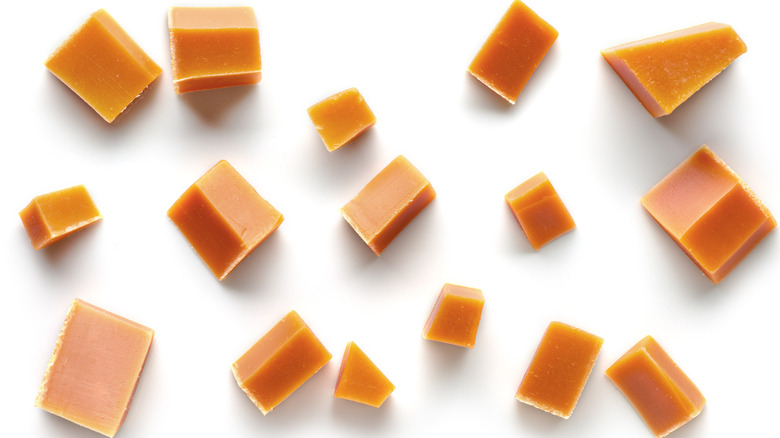 Caramel pieces on white background 