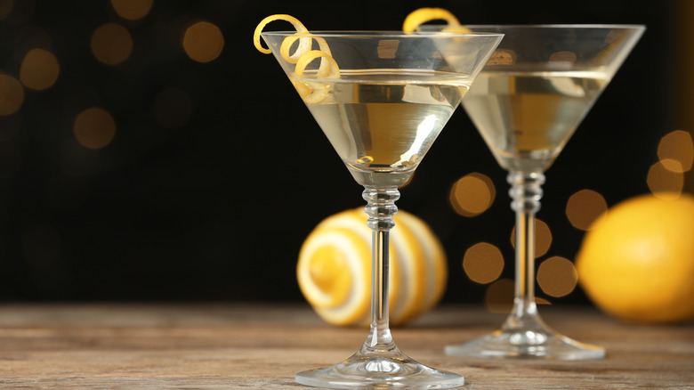 Classic Dry Martini with olives on grey table against black background