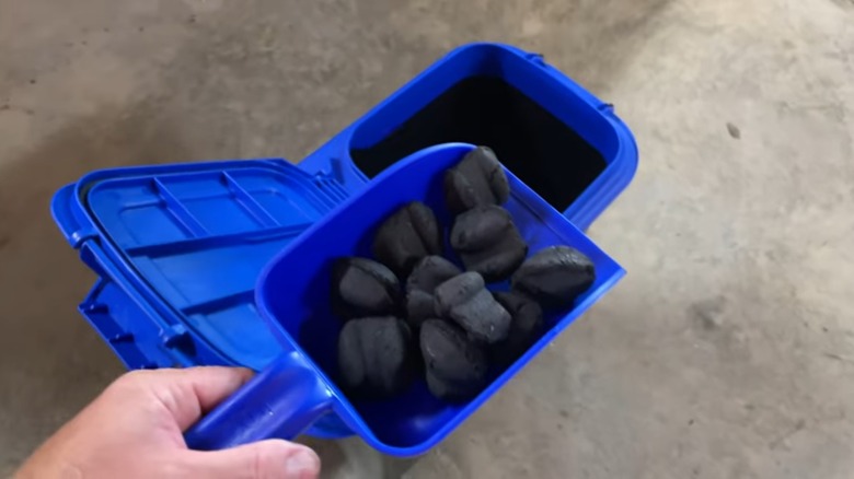 Charcoal being placed in a storage bin