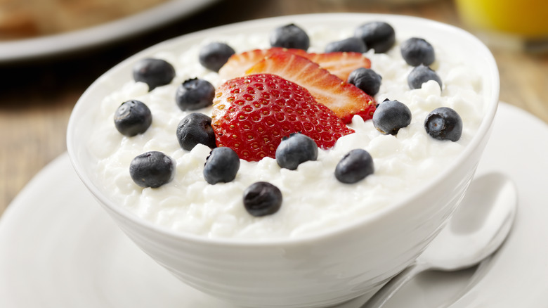 A bowl of cottage cheese with strawberries and blueberries