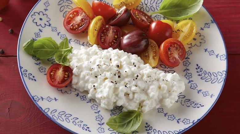 Cottage cheese on plate with halved cherry tomatoes