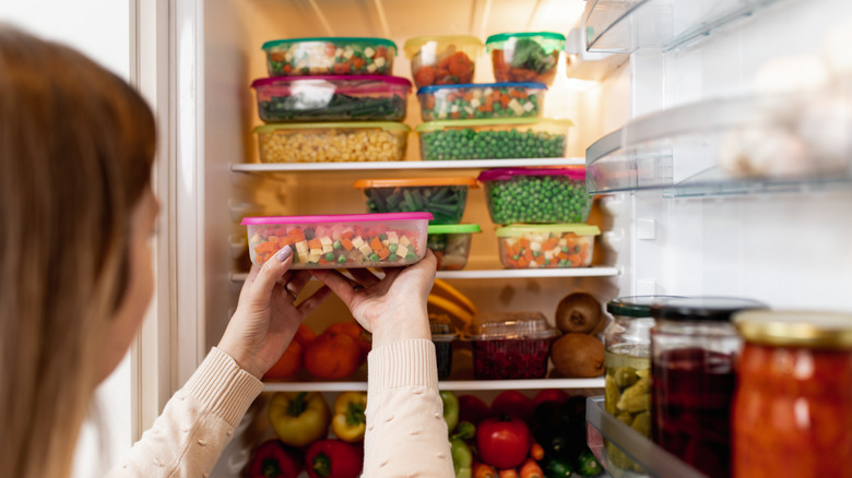 Woman storing food in fridge