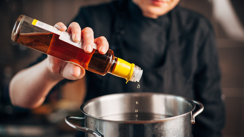 Pouring vinegar into poaching pot