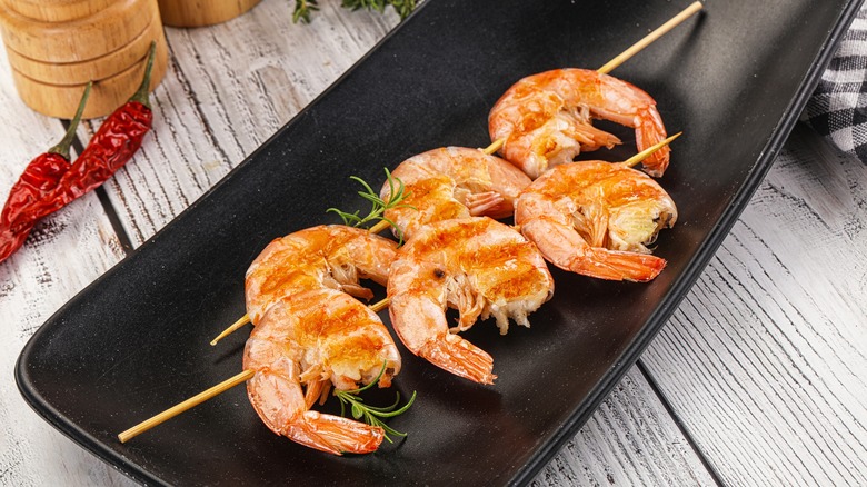 Skewered shrimp on black plate