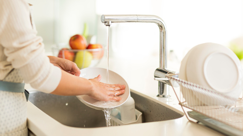 pre-rinsing dish in sink