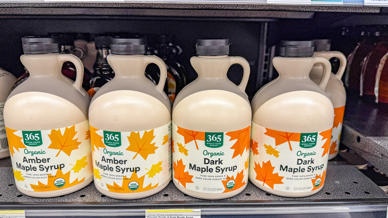 Jugs of maple syrup on a grocery store shelf