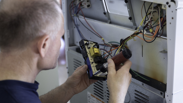 man attaching wires to stove