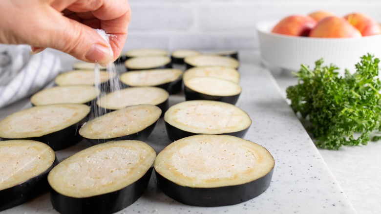 hand salting eggplant slices