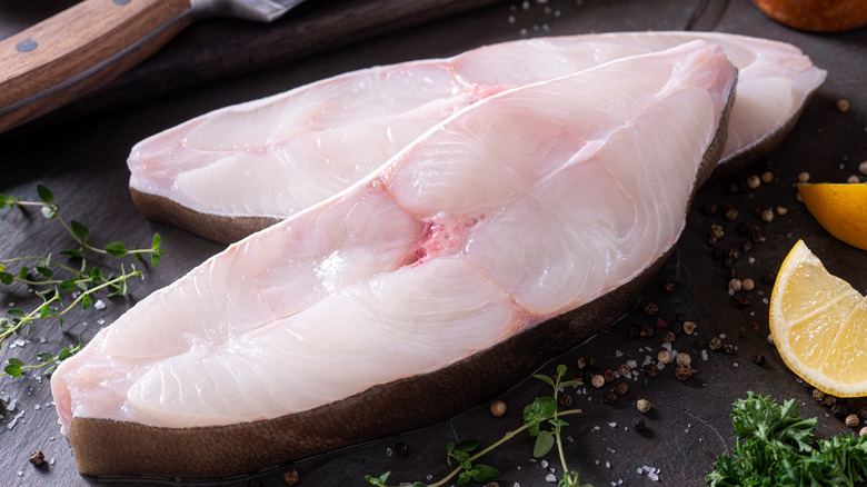 Halibut steaks with lemon wedges