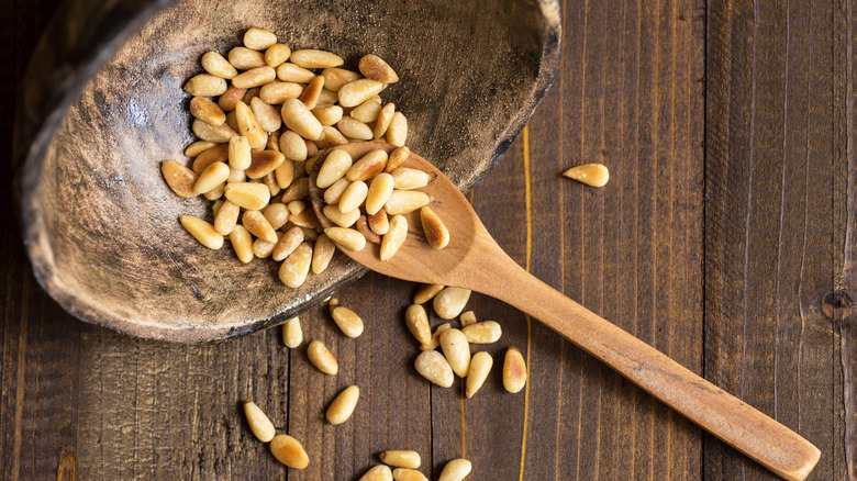 Toasted pine nuts on a wooden spoon