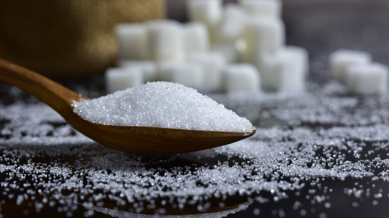 white sugar in wooden spoon