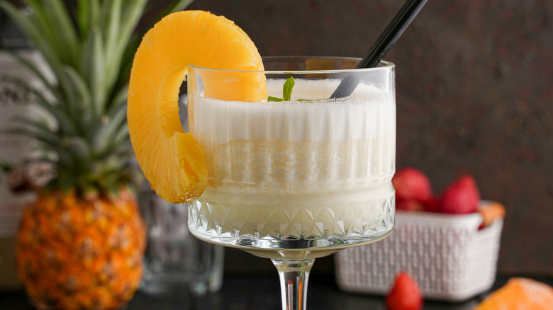 Glass of a frozen piña colada with a pineapple slice garnish