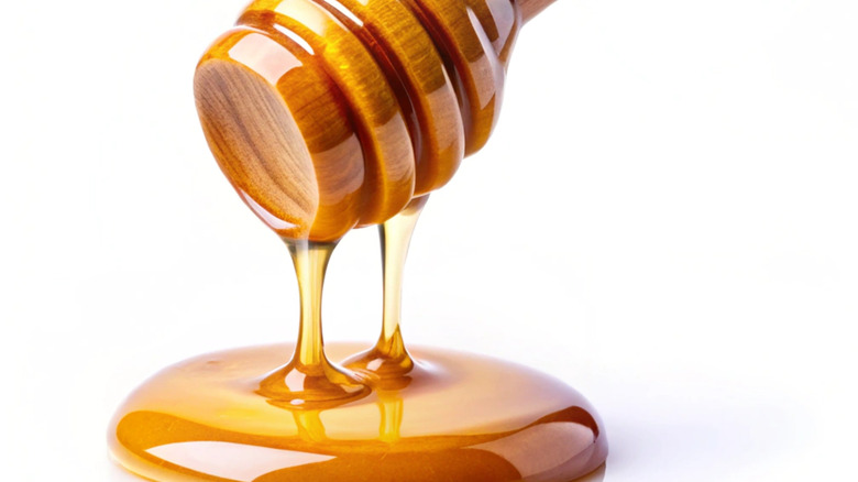 Honey dripping from a wooden honey dipper