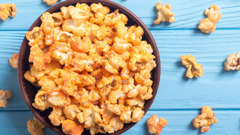 cheese popcorn in bowl on blue background