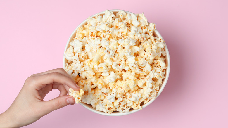 popcorn in bowl with woman's hand