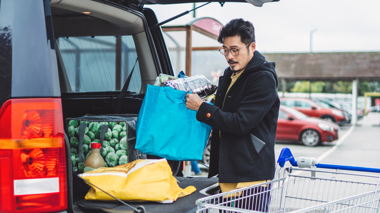 Man handling groceries in reusable bags