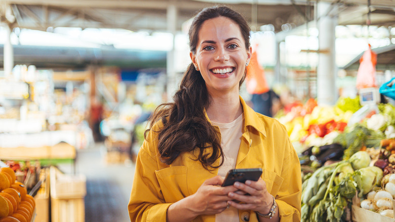 Woman in supermarket holding phone