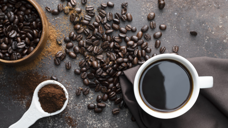 Coffee cup, beans, and scoop