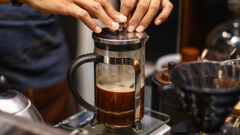 Person pressing down French press