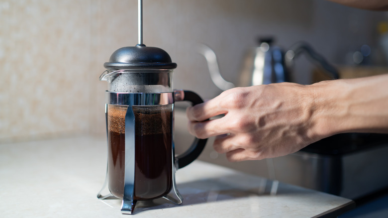 Person brewing French press coffee