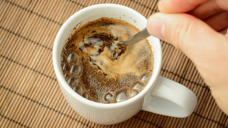 Stirring coffee cup with spoon