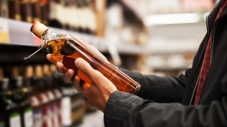 person holding liquor bottle