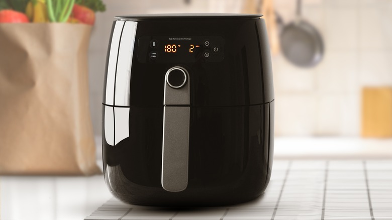 Black air fryer sitting on kitchen counter