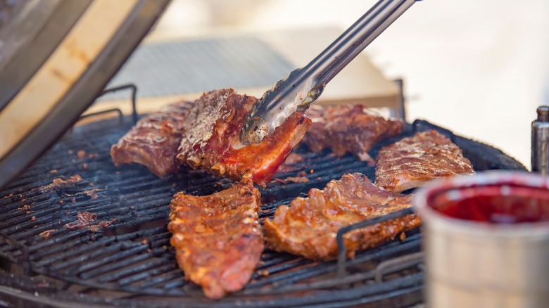 ribs on grill tongs